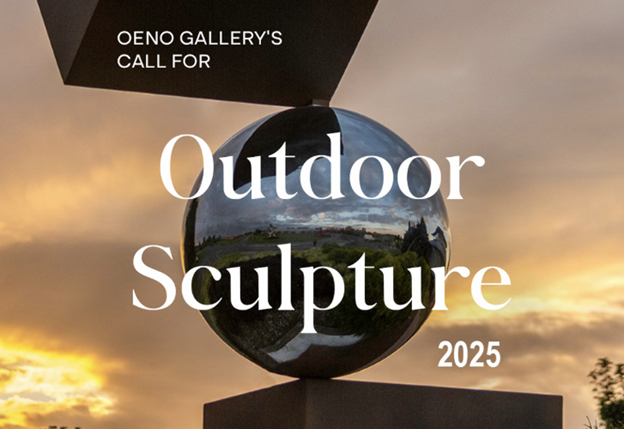 Outdoor sculpture with large silver metal reflective ball between two cubish structures with a background of cloud filled orange sunset sky 