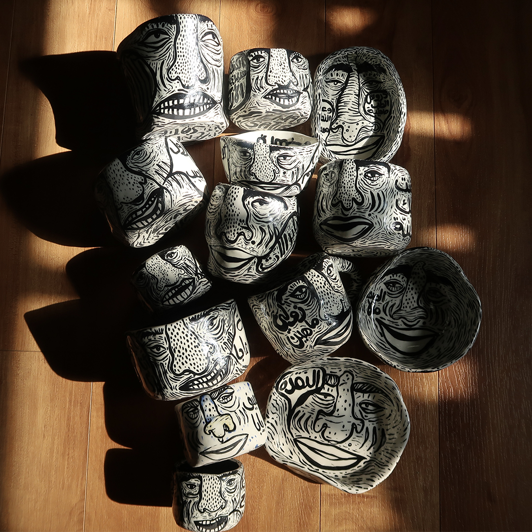 Photo of ceramic bowls and cups painted with faces